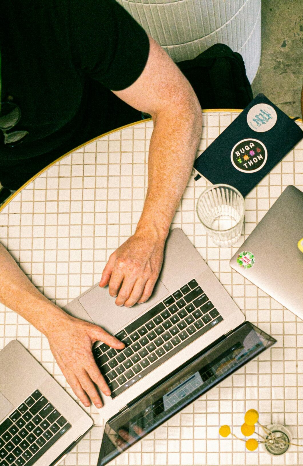 Top view of a team collaborating with laptops, phones, and notes in a modern office.